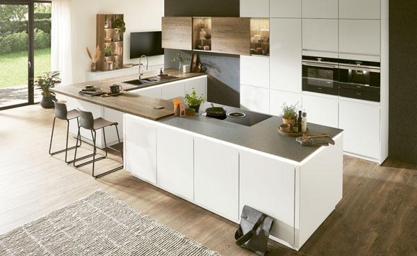Helle Einbauküche mit weißer Kochinsel, Holzarbeitsplatten und Barhockern