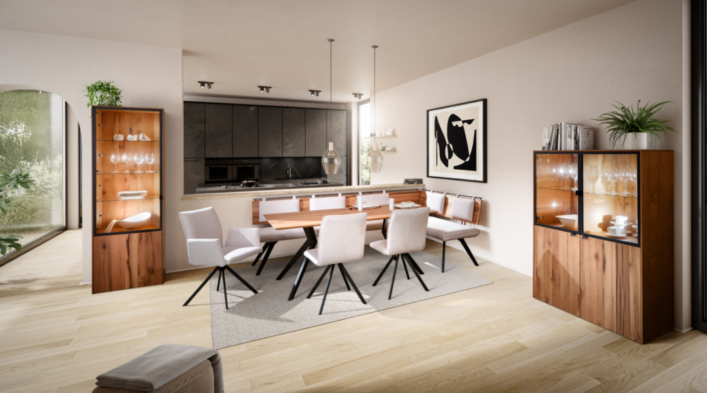 Schösswender Esszimmer-Kombination: massiver Esstisch mit schwarzem Spinnengestell und Holzbank, sechs cremefarbene Drehstühle mit Armlehnen, flankiert von zwei beleuchteten Vitrinenschränken in Wildeiche mit schwarzem Metallrahmen – offener Wohnraum mit Blick in dunkle Einbauküche