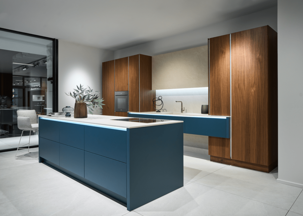 Häcker Design-Küche grifflos: Kontrastreiche Kombination aus blauen Fronten, dunklem Holz und heller