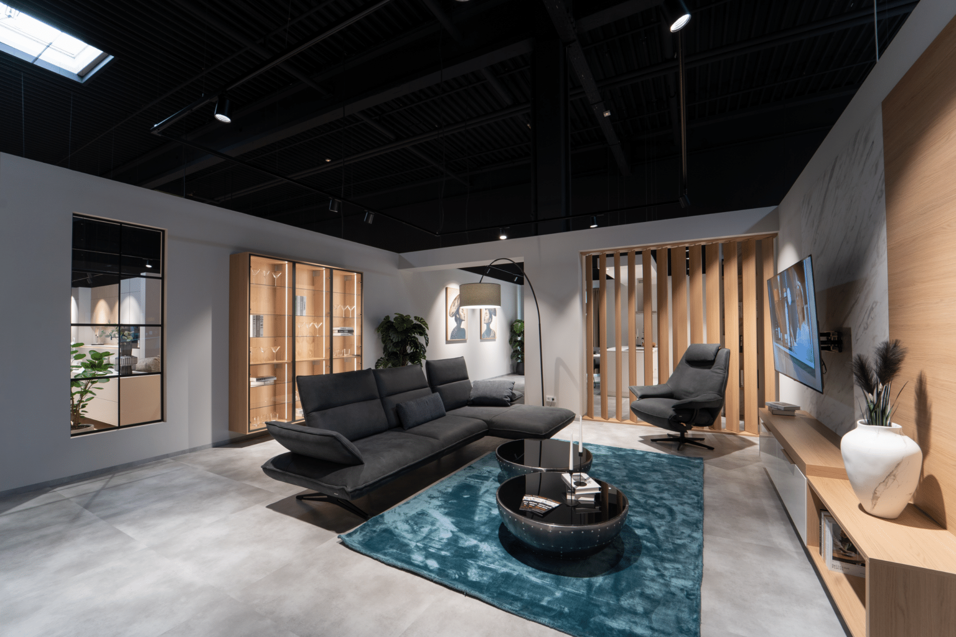Wohnausstellung im Küchenstudio Viernheim mit Ledersofa, Sessel und Glasvitrinen