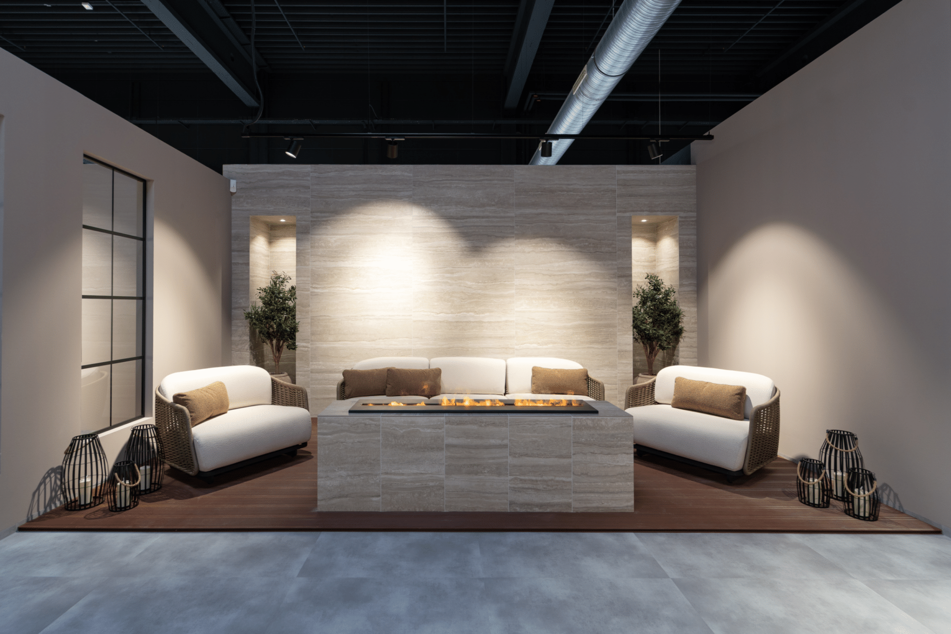 Lounge-Bereich im Küchenstudio Viernheim mit Sesseln und Steinwand mit Kaminelement