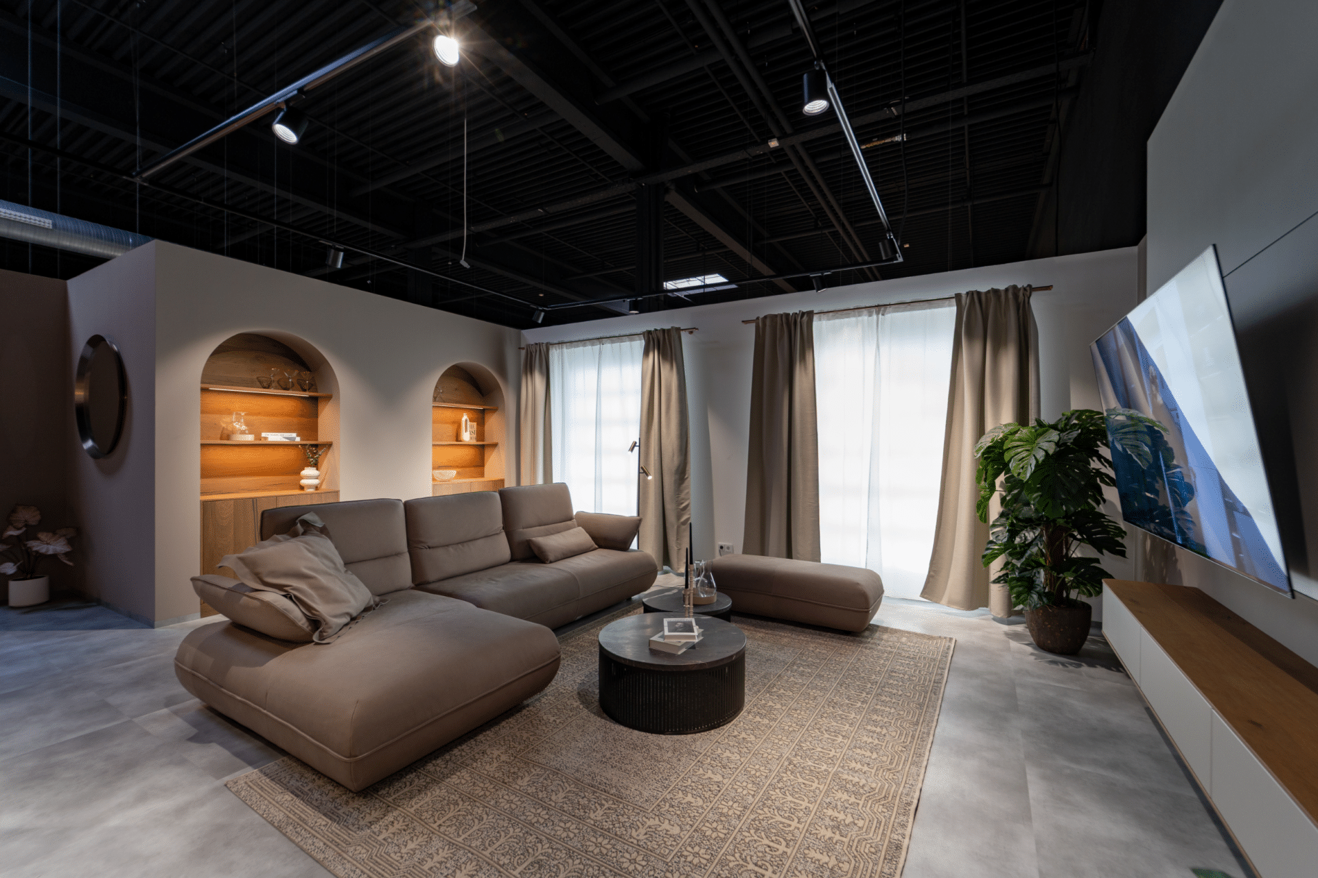 Wohnbereich in der Ausstellung im Küchenstudio Viernheim mit Ecksofa, Teppich und Bogennischen