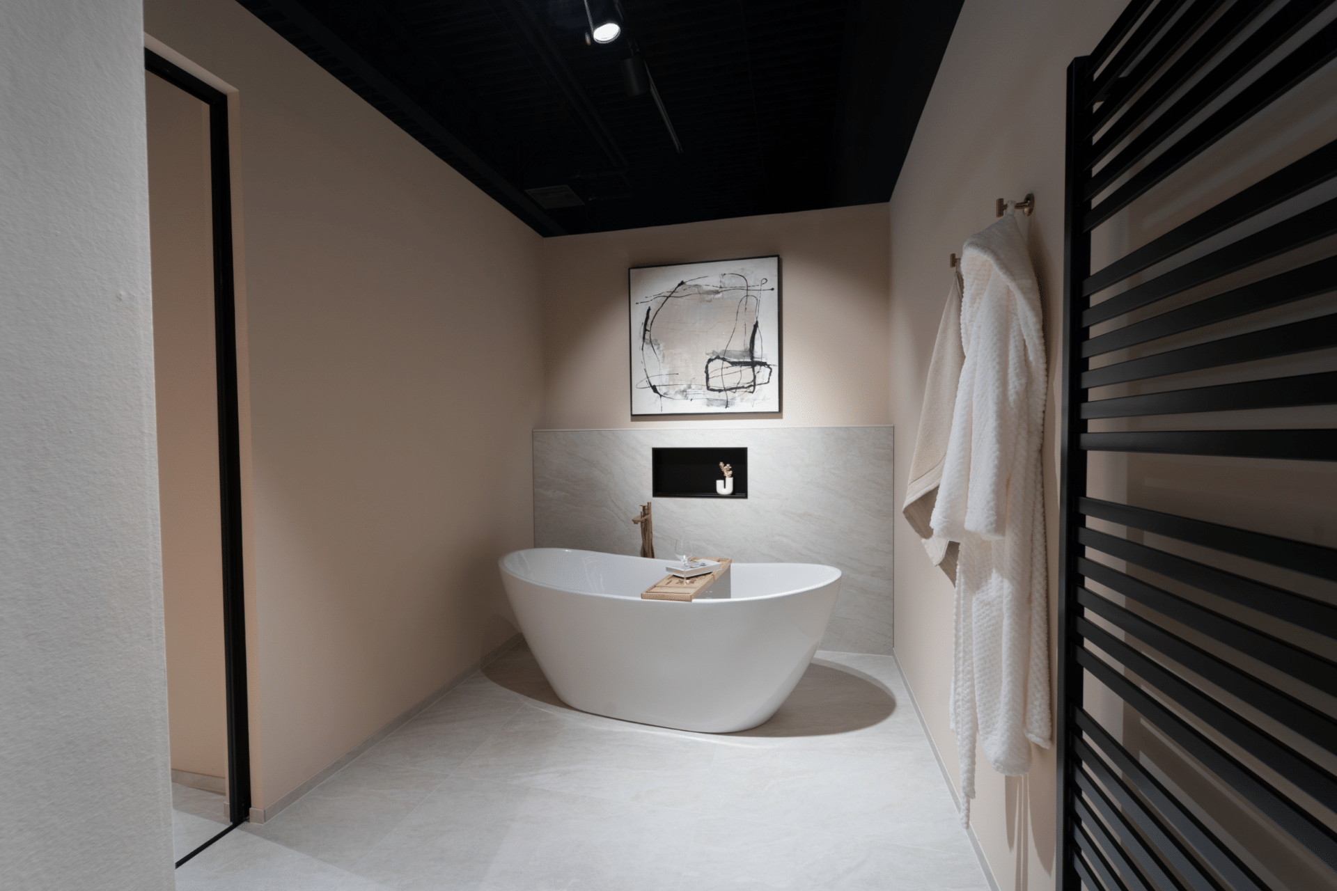 Badausstellung im Küchenstudio Viernheim mit freistehender Badewanne und schwarzem Handtuchheizkörper
